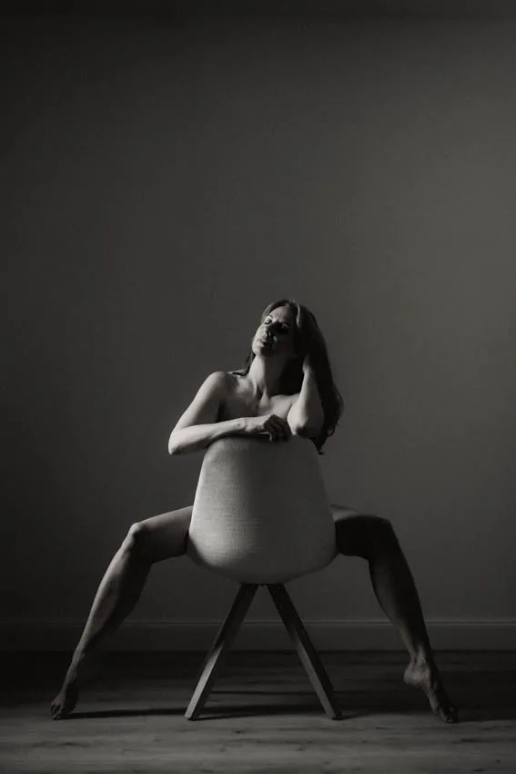 nackte Frau am Stuhl in sinnlicher Pose