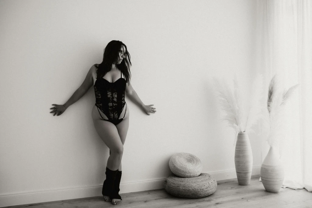Frau ist beim Boudoirshooting Graz ganz im Moment - mit Spitzenbody und Legwarmer