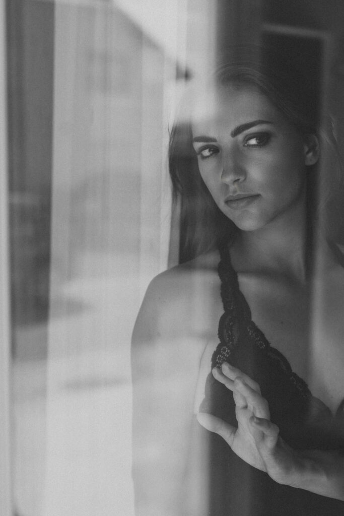 Boudoir Fotografin Graz: Frau an Fensterscheibe