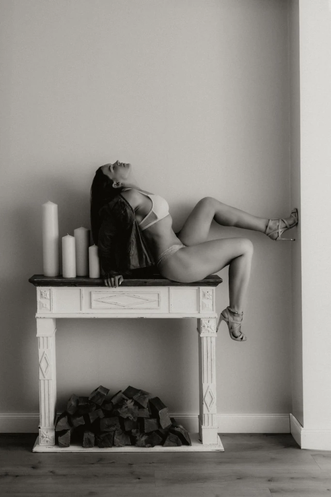 Frau in Unterwäsche sitz mit Highheels am Kamin