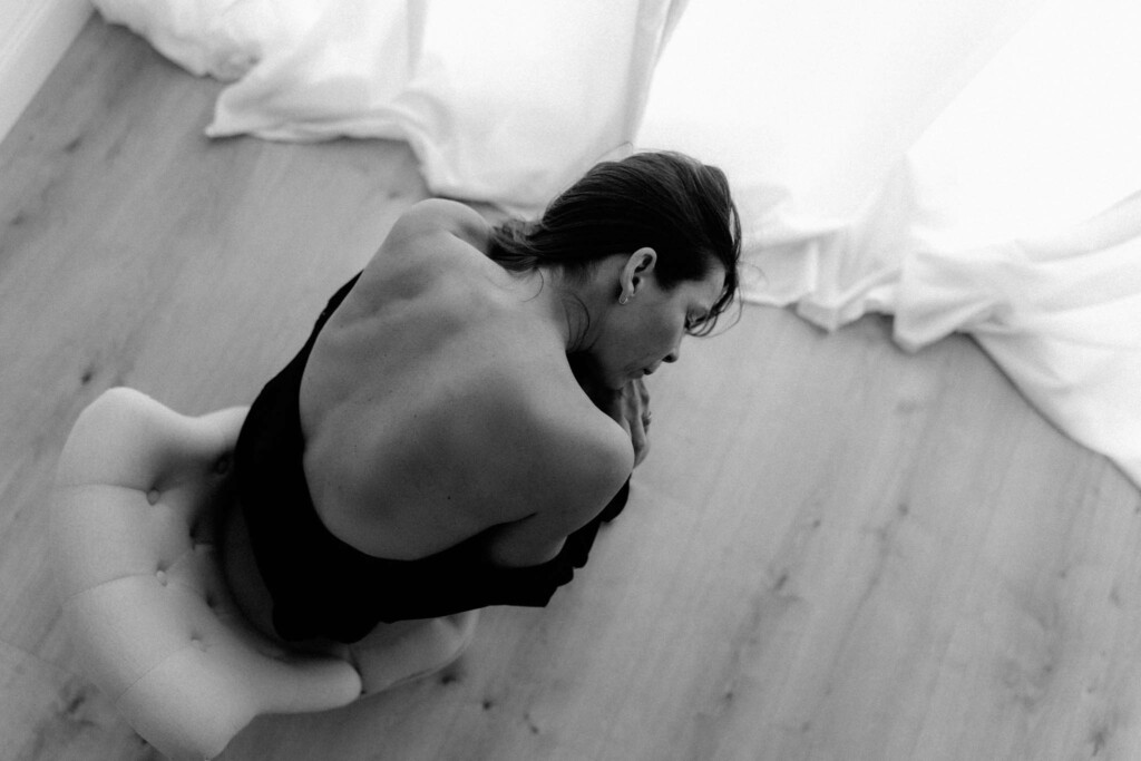 nachdenkliches Boudoirfoto von Frau am Stuhl mit freiem Rücken