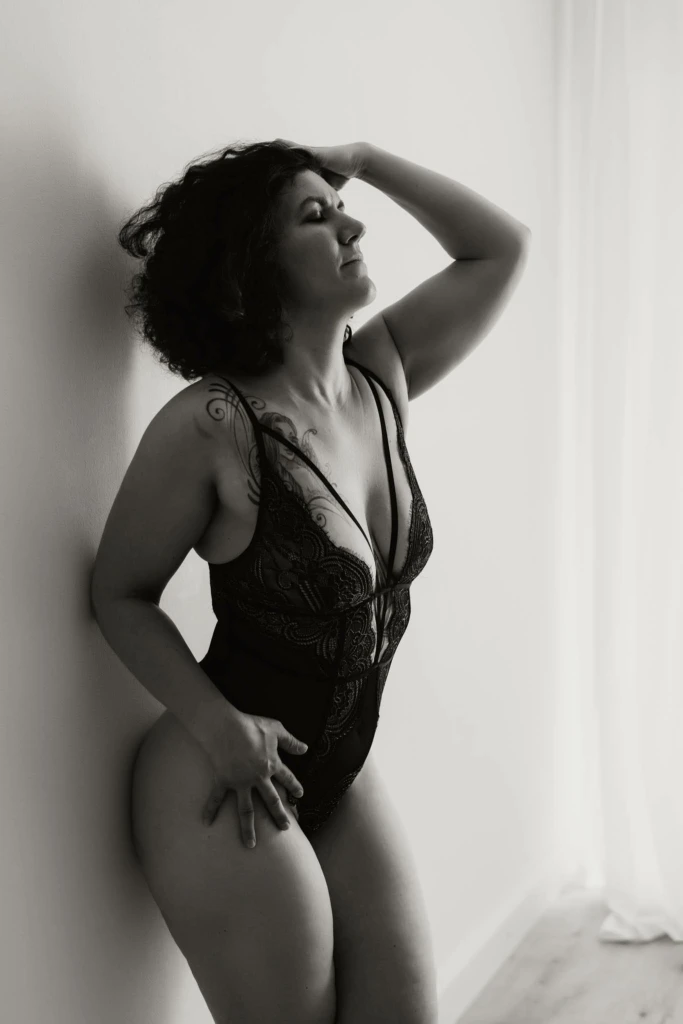 Frau in schwarzer Unterwäsche lehnt sinnlich an der Wand - Boudoirfoto Graz