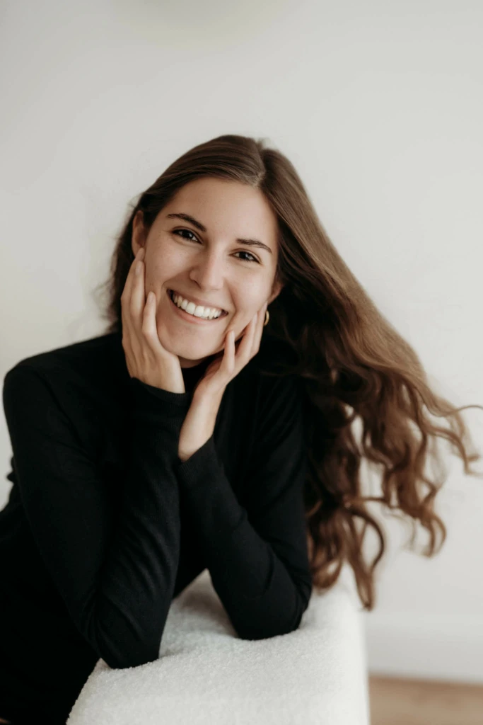 offenes Lachen einer jungen Frau mit Sommersprossen und wehenden Haaren