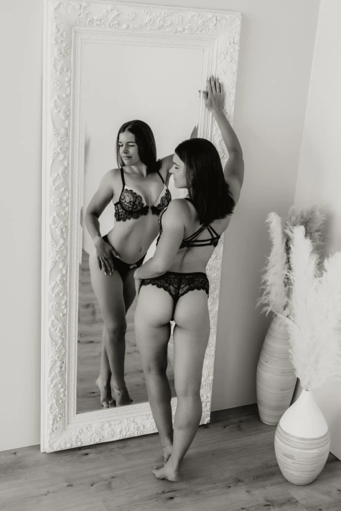 Frau in Unterwäsche steht vorm Spiegel - Boudoir